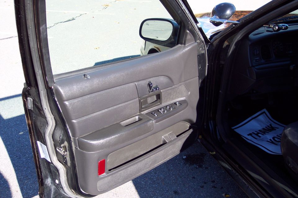 2001 Ford Crown Victoria interior door panel with power window controls and a "Thank You" mat on the floor