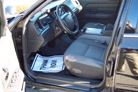 2001 Ford Crown Victoria - Interior view of a 2001 Ford Crown Victoria, front seats and dashboard. 'THANK YOU!' floor mat visible.