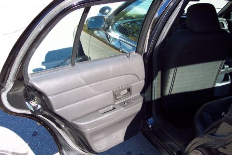 2001 Ford Crown Victoria - The interior of a 2001 Ford Crown Victoria is shown, focusing on the rear passenger door and seating area.