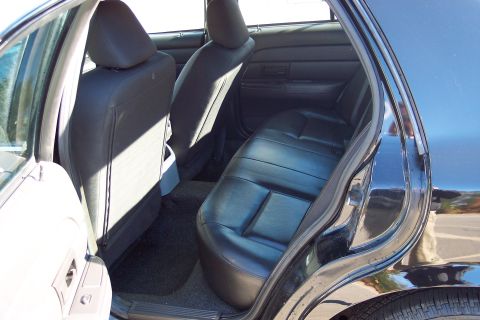 2001 Ford Crown Victoria - Interior view of a black car's back seat and door frame.