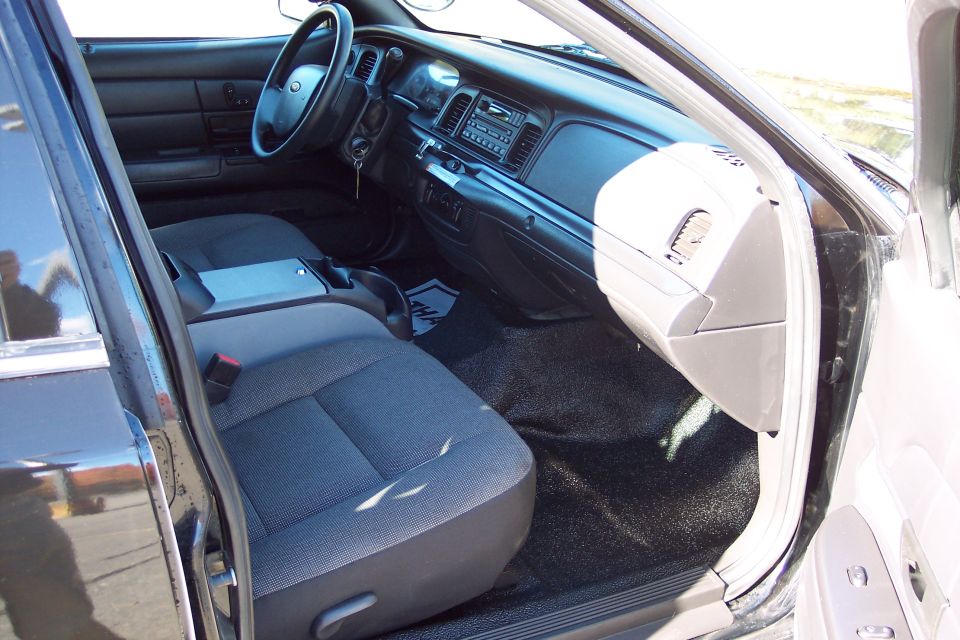 Interior of a 2001 Ford Crown Victoria police car, showing front seats and dashboard