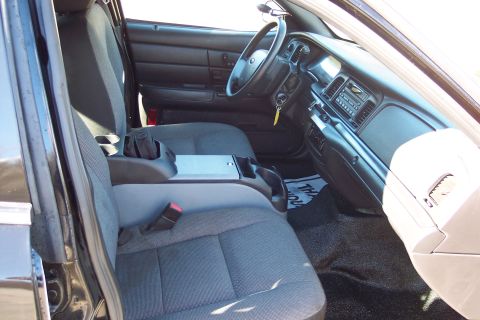 2001 Ford Crown Victoria - Interior of a 2001 Ford Crown Victoria police car, showing the driver and passenger seats and the dashboard.