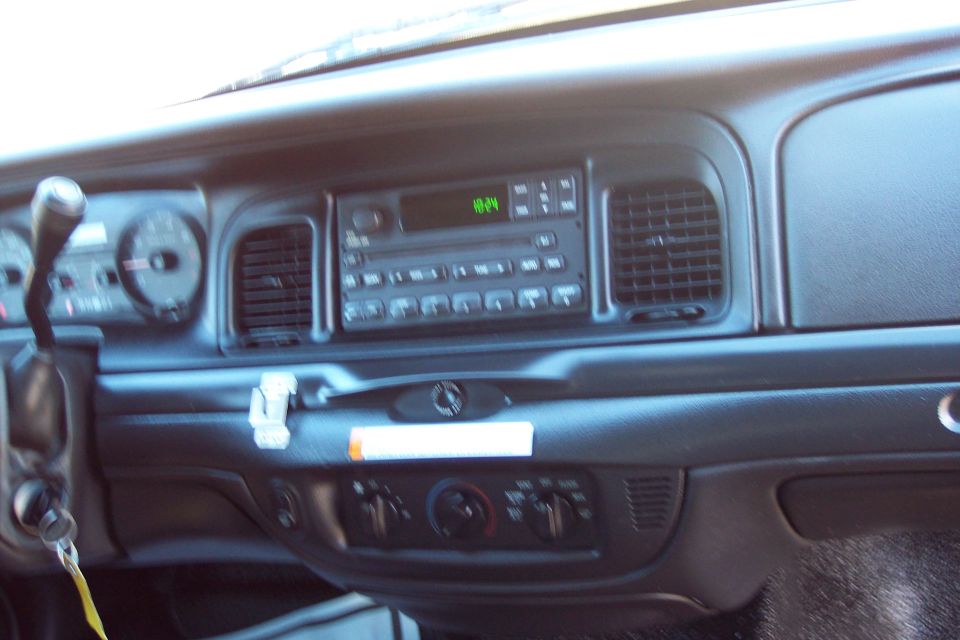 dashboard of a police car, showing radio, vents, and climate controls