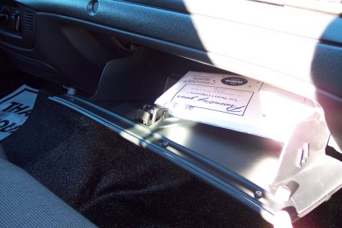 2001 Ford Crown Victoria - Interior view of an open glove compartment with a document inside.