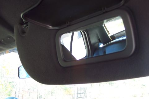 2001 Ford Crown Victoria - The visor mirror reflects the interior of the vehicle, including the back seat and a window.