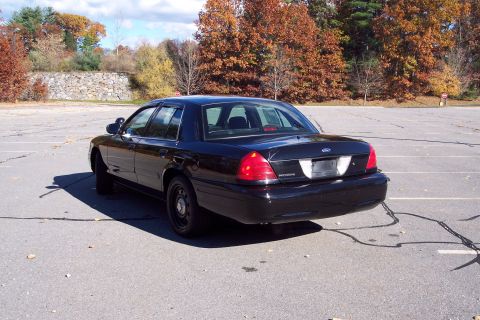 2001 Ford Crown Victoria - Rear view of a black 2001 Ford Crown Victoria sedan parked outdoors.