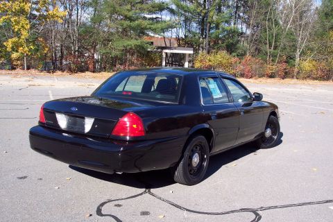 2001 Ford Crown Victoria - Rear three-quarter view of a black Ford Crown Victoria with black steel wheels.