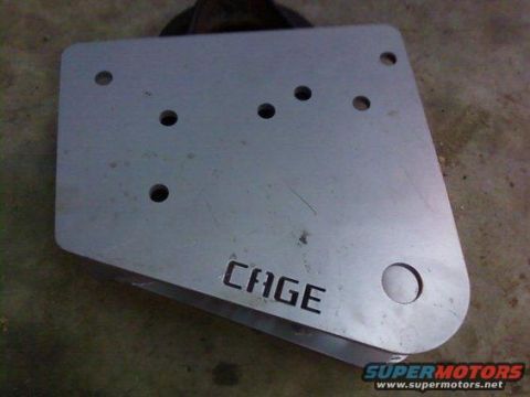 1995 Ford Bronco - A metal plate with multiple holes and the word CAGE is shown against a textured background.