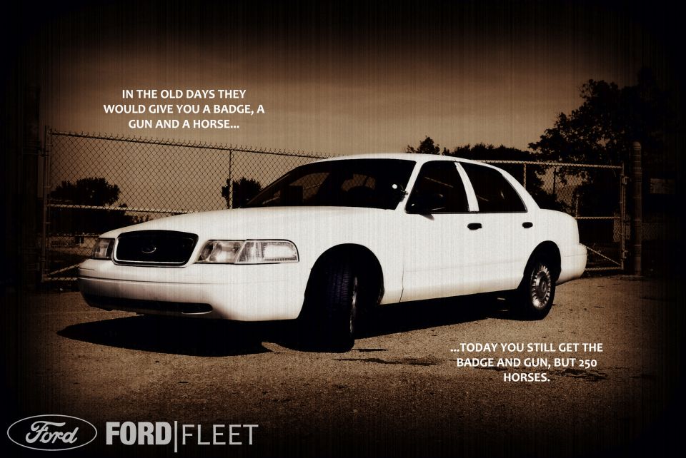 White 2002 Ford Crown Victoria Police Interceptor parked outside a fence