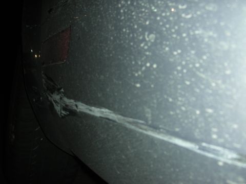 1998 Ford Crown Victoria - Scraped and damaged car bumper shows signs of impact.