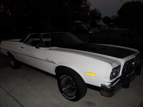 1973 Ford Ranchero - A white 1973 Ford Ranchero with a black hood stripe is shown from a three-quarter front angle at dusk.