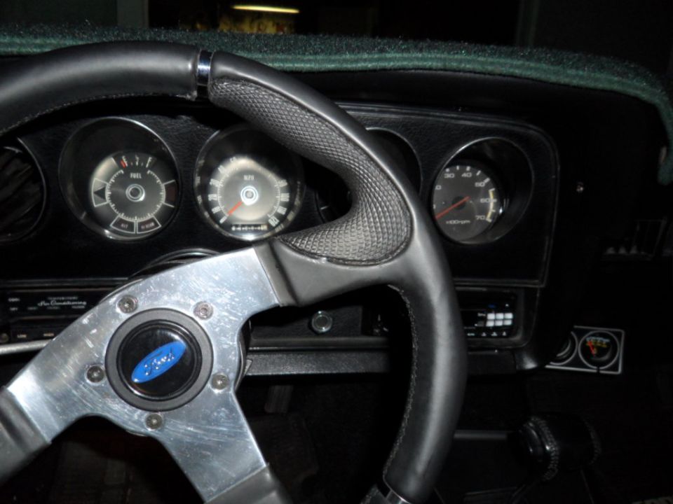 Interior view of a 1973 Ford Ranchero with a custom steering wheel and dashboard gauges