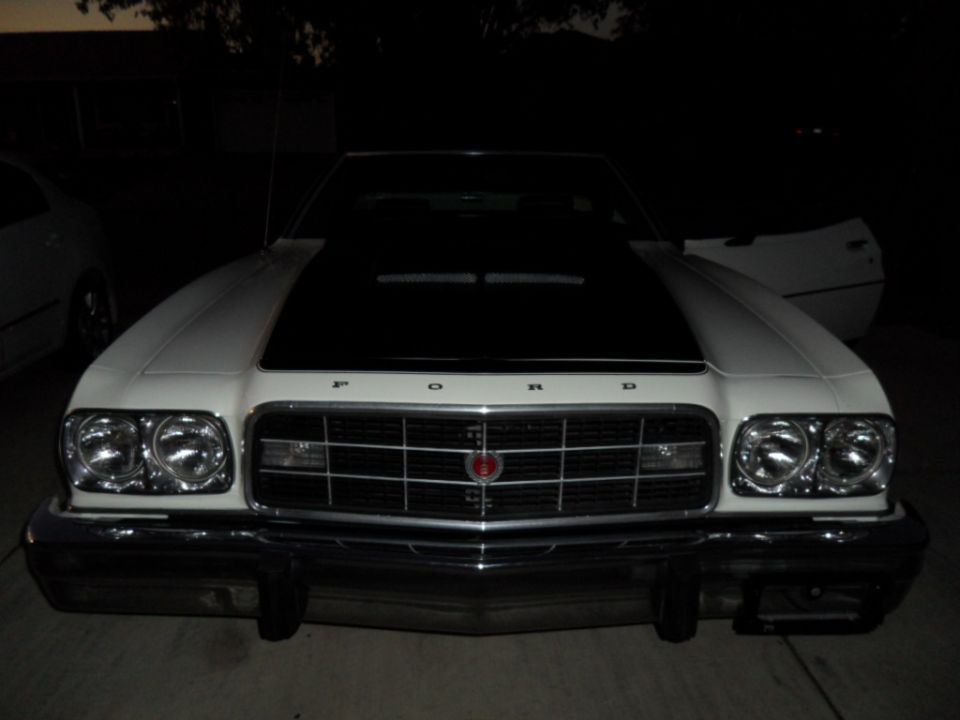 White 1973 Ford Ranchero front view, black hood, chrome grille, dual headlights