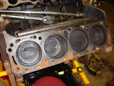 1989 Ford Bronco - Close-up of an engine block with pistons visible, undergoing repair with tools nearby.
