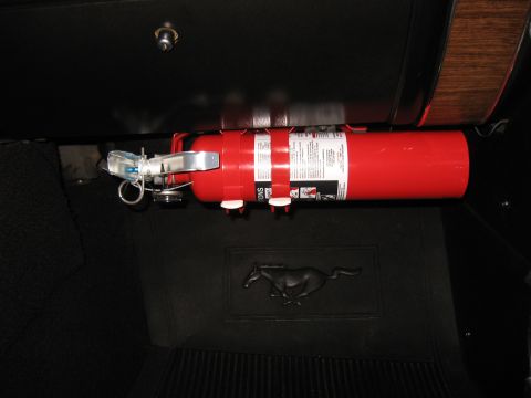 1968 Shelby GT500 - A red fire extinguisher is secured beneath the dashboard, with a classic Mustang emblem visible on the floor mat.