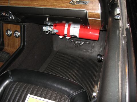 1968 Shelby GT500 - The interior of a 1968 Shelby GT500 features a fire extinguisher mounted under the dash and a prominent running horse emblem on the passeng…
