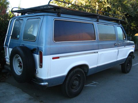 1989 Ford Bronco - This van has a two-tone paint job and a ladder on the driver's side.