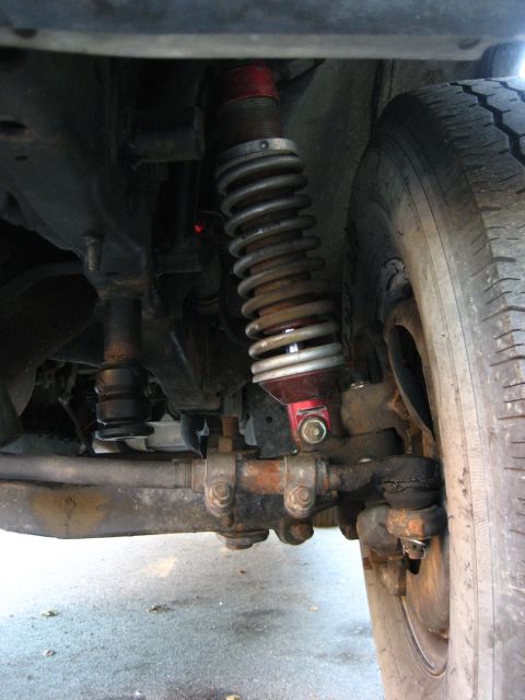1989 Ford Bronco - Close-up view of the front suspension system, including the shock absorber and tire.