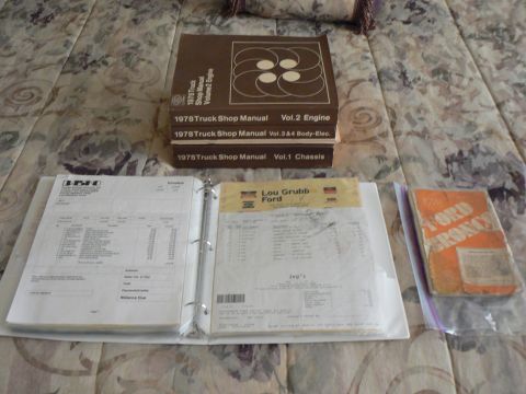 1978 Ford Bronco - Shop manuals and receipts related to a 1978 Ford Bronco are laid out on a patterned surface.