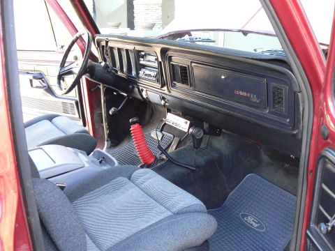 1978 Ford Bronco - The interior of a 1978 Ford Bronco features a red shifter boot and Ford-branded floor mats.