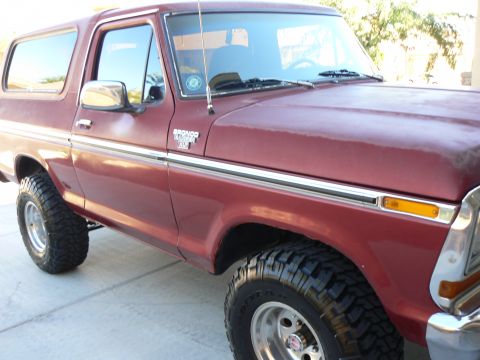 1978 Ford Bronco - This 1978 Ford Bronco features a prominent chrome side trim and aggressive off-road tires.