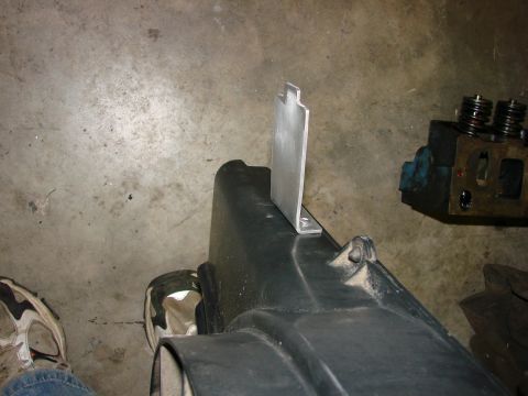 1991 Jeep Comanche - Engine part with a custom metal bracket attached, sitting on a concrete floor.