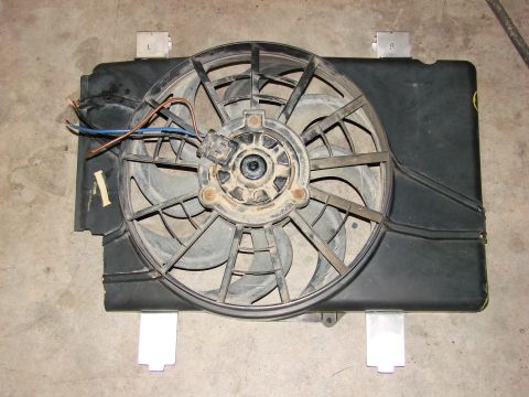 1991 Jeep Comanche - A radiator fan assembly is shown, detached from a vehicle, with visible wiring and mounting brackets.
