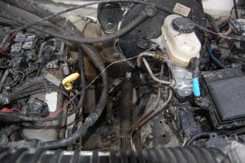 1994 Ford Bronco - Engine bay shows significant damage to wiring and components, possibly from a fire.