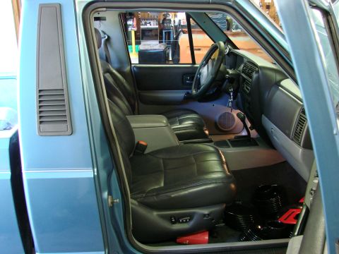 1991 Jeep Comanche - The interior of a blue 1991 Jeep Comanche shows black leather seats and the dashboard.