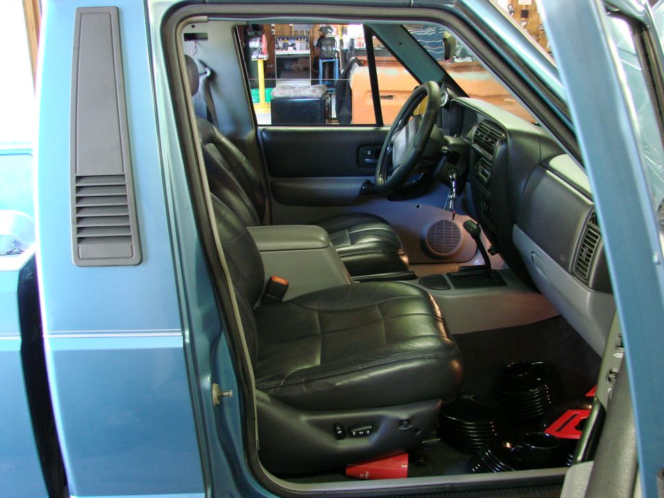 Blue 1991 Jeep Comanche interior with black leather seats, dashboard, and steering wheel