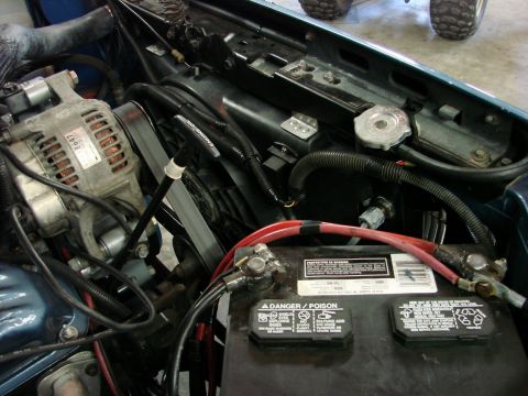 1991 Jeep Comanche - Close-up view of the engine bay, focusing on the alternator and battery components.