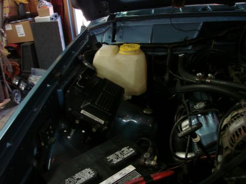1991 Jeep Comanche - Engine bay of a 1991 Jeep Comanche, the coolant reservoir and battery.