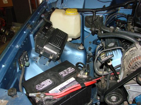 1991 Jeep Comanche - Close-up of a Jeep's engine bay, showing the battery, fuse box, and other engine components.