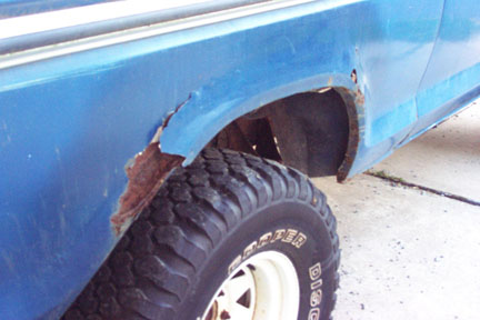1979 Ford Bronco - Rust damage is evident on the rear fender of a blue SUV, obscuring any specific year identification.