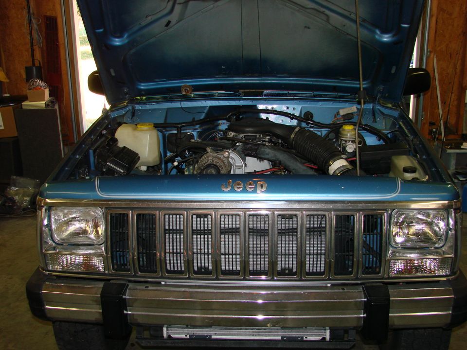 1991 Jeep Comanche engine bay with hood open, showing engine and front grille