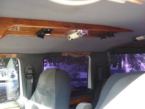 1992 Ford C-350 (Centurion Conversions) - Van or SUV interior ceiling featuring a polished wood overhead console with track-style spotlights and tinted rear windows.