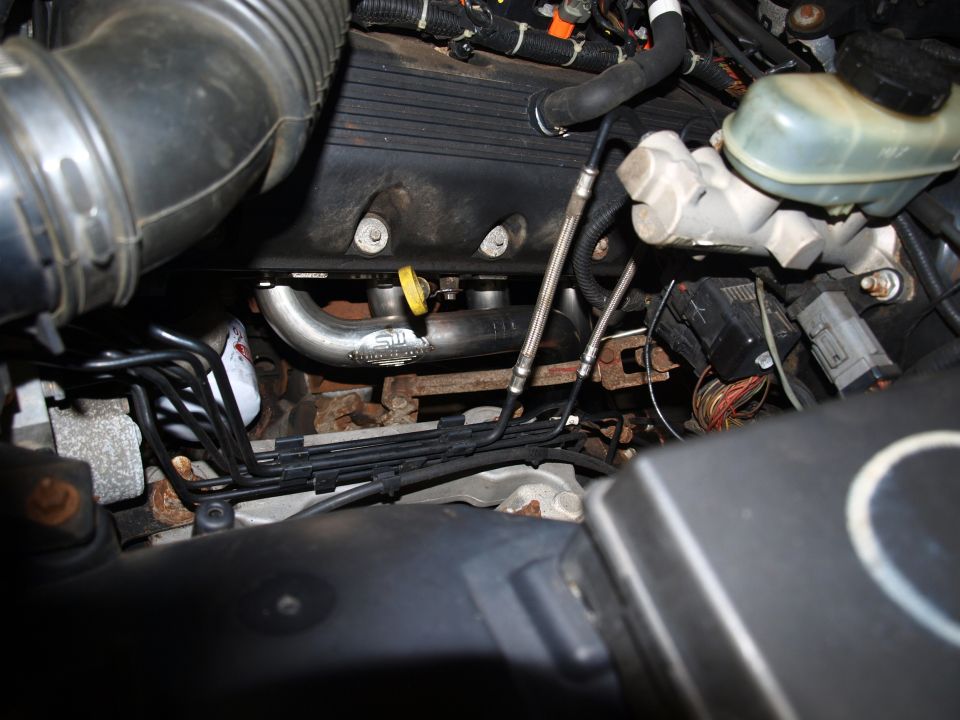 Engine compartment with custom exhaust headers and wiring