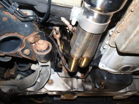 1998 Ford Crown Victoria - Underside close-up of a stainless header collector merging into a heat-tinted pipe with an oxygen sensor threaded into the bung, tucked alo…