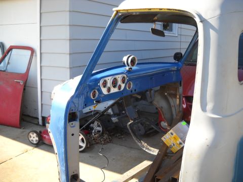 1954 Ford F-100 - The interior of a 1954 Ford F-100 pickup truck, undergoing restoration with a blue painted dashboard and new gauges.