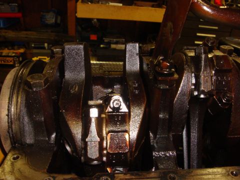 1989 Ford Bronco - Close-up view of the engine's crankshaft and connecting rods, covered in oil.