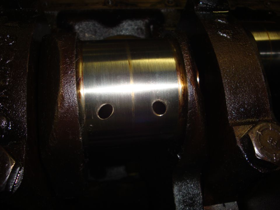 Engine crankshaft bearing with oil holes