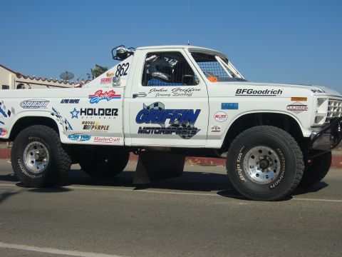 1986 Ford Bronco - This white off-road truck displays numerous sponsor decals and racing numbers.