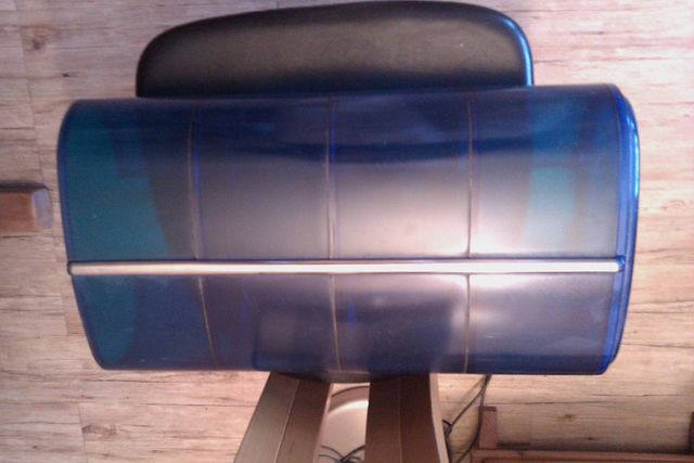 Blue car door panel with horizontal trim strip, resting on a stand