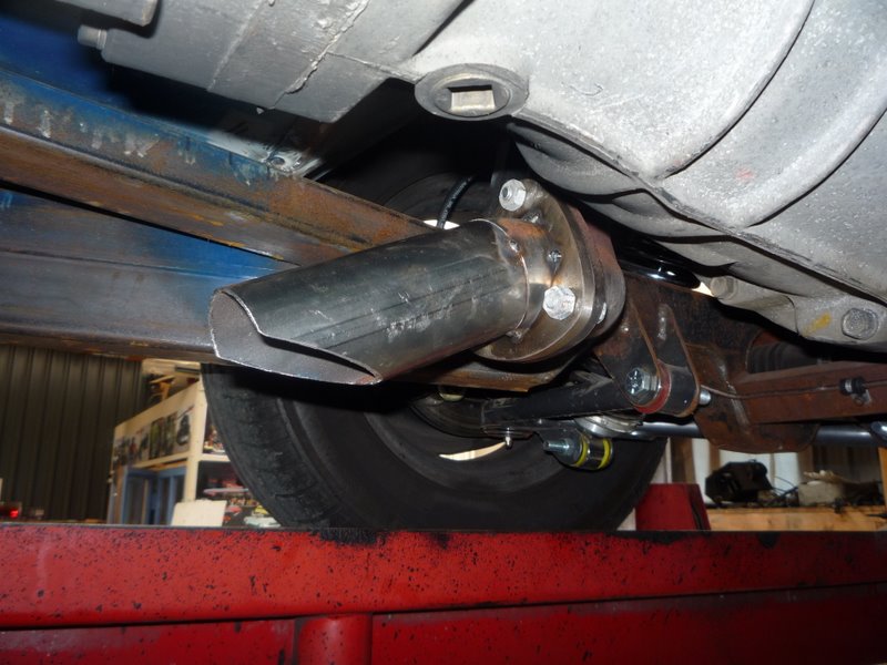 Custom exhaust pipe attached to suspension components under a vehicle