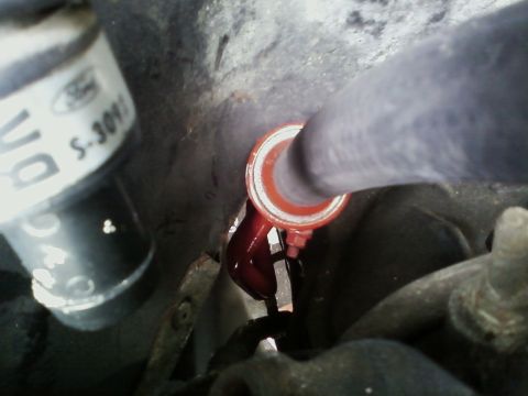 1990 Ford Bronco - Ford part S-309 with red fluid visible, likely from an exhaust or fluid line.