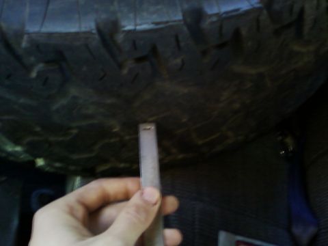 1990 Ford Bronco - Measuring tire tread depth with a ruler.