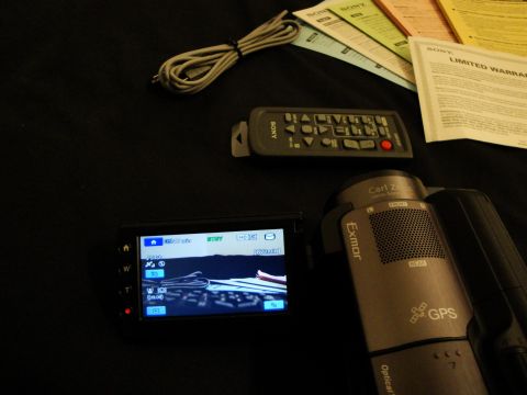 1993 Ford Taurus - A Sony camcorder, remote control, cables, and instruction manuals are laid out on a dark surface.