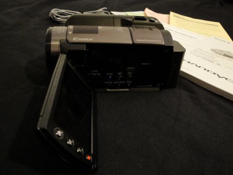 1993 Ford Taurus - A Sony Handycam camcorder is shown with its LCD screen open, resting on a dark surface next to manuals.