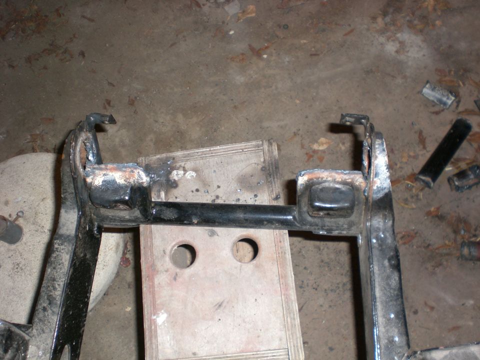 Welded steel suspension or frame bracket assembly resting on a shop floor
