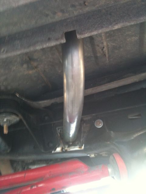 1982 Ford Bronco - A close-up view of a vehicle's exhaust pipe and undercarriage components.